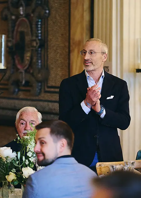 A host on his feet giving a speech at lunch