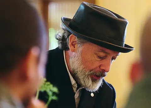 A bearded guest in a hat, portrait in warm light