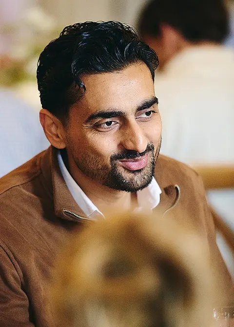 A guest with a light beard, candid smile