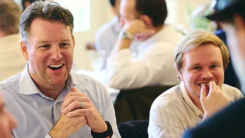Two guests laughing at the dinner table