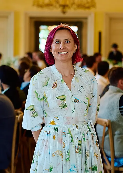 A guest in a floral dress standing in the dining hall