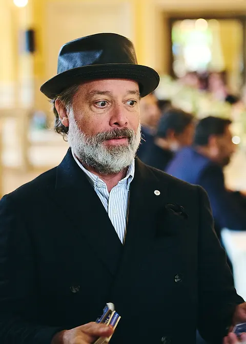 A guest in a hat speaking with the table