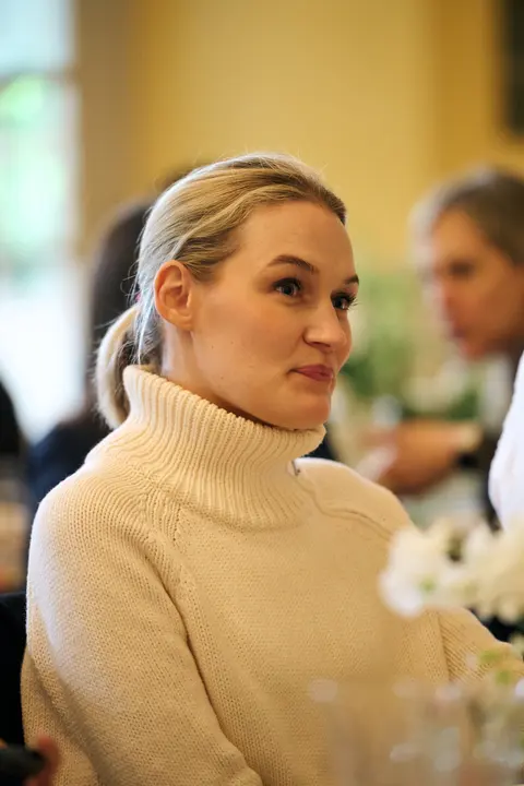A guest in a dark top, smiling candidly