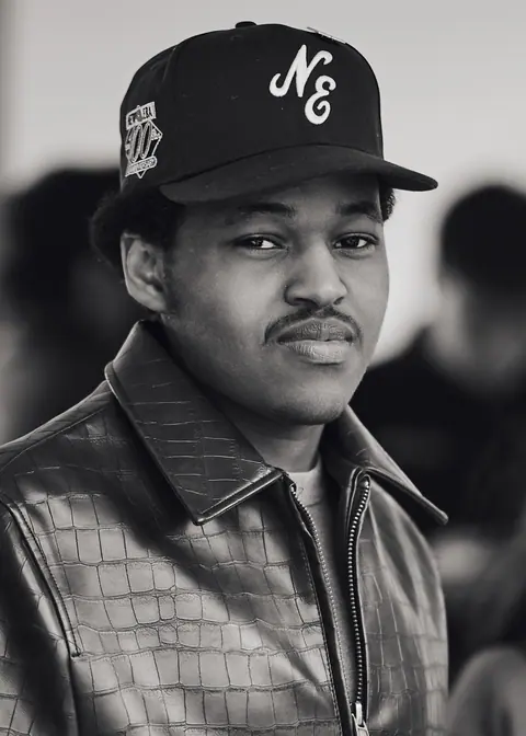 Black and white portrait of a young guest in a cap and leather jacket