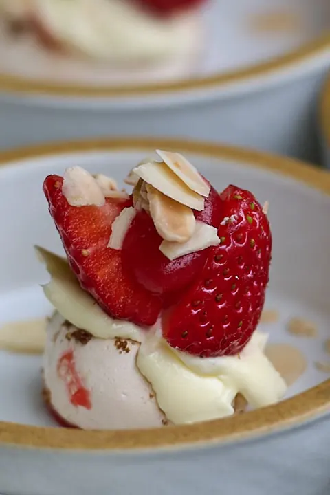 Desserts with strawberries and cream on small plates