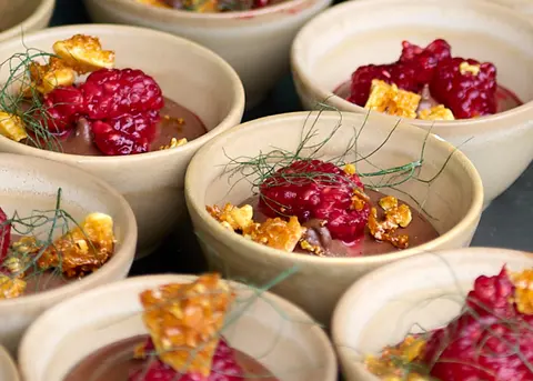 Small bowls of a berry dessert arranged on a tray