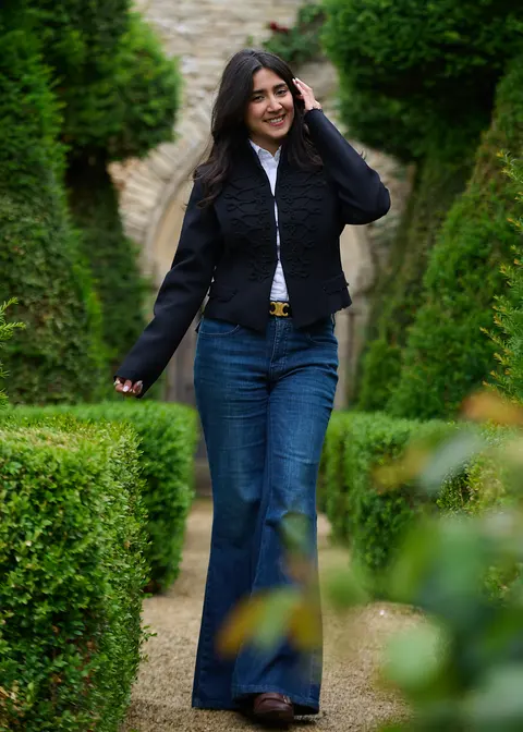 A guest walking along a hedged garden path