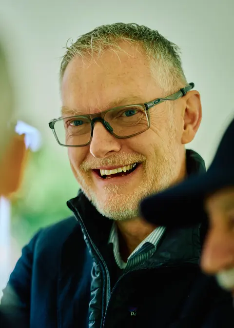 A black and white portrait of a guest smiling