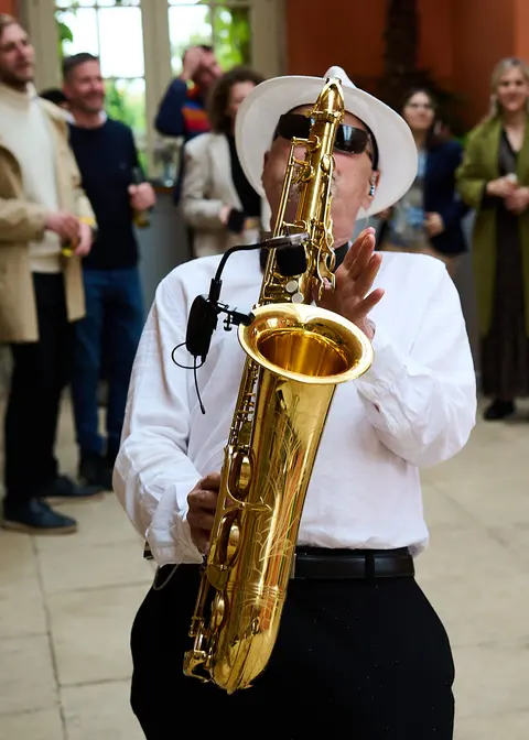 A saxophonist playing with the band