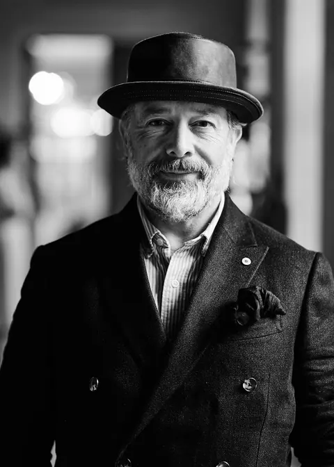 Black and white portrait of a bearded man in a hat and double breasted jacket