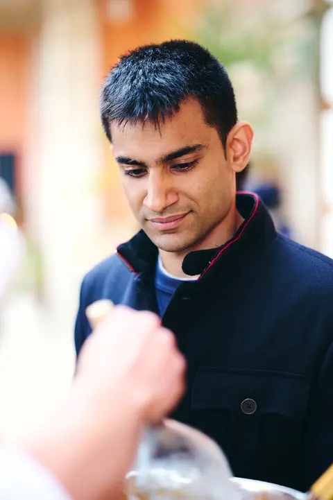 A guest in conversation holding a glass of wine