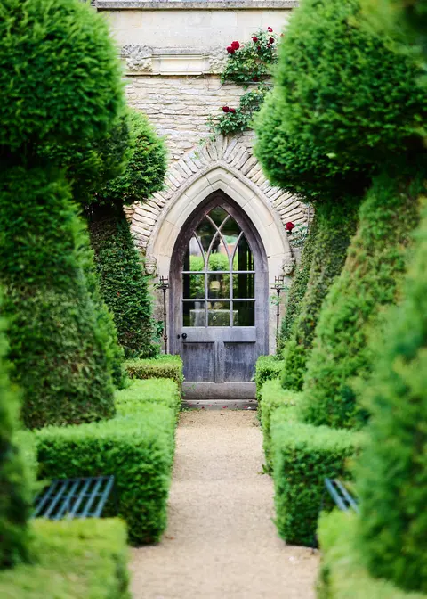 A gothic arched door between clipped yew topiary