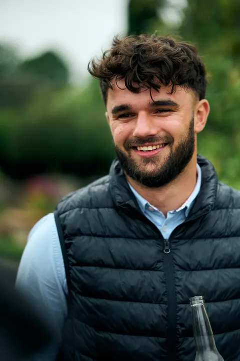 A guest in a jacket smiling candidly