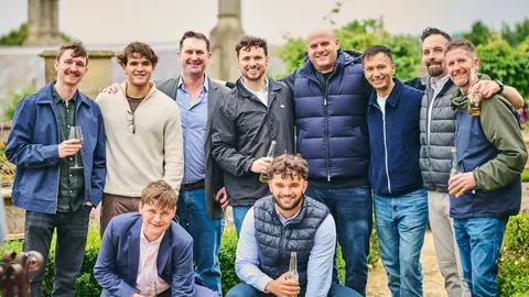 A group photo of colleagues in the garden with the house behind